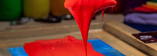 Bright red ink additive pouring onto a printing surface, illustrating its use in modern ink formulations.